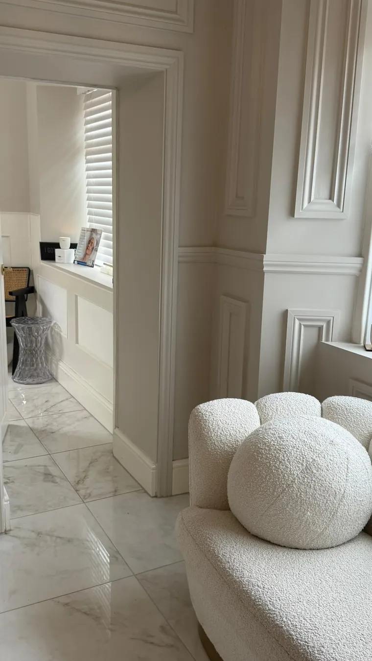 The reception of The Self-Care Clinic with a boucle chair and marble floors