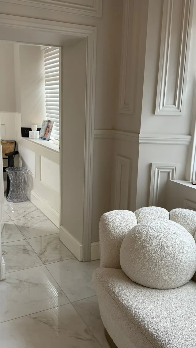 A boucle chair and marble floors in the clinic reception